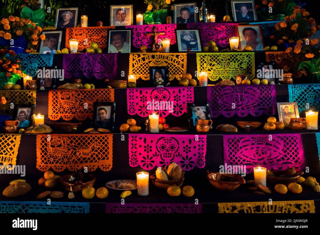 Food offerings and pecked paper flags are placed at the altar of the ...