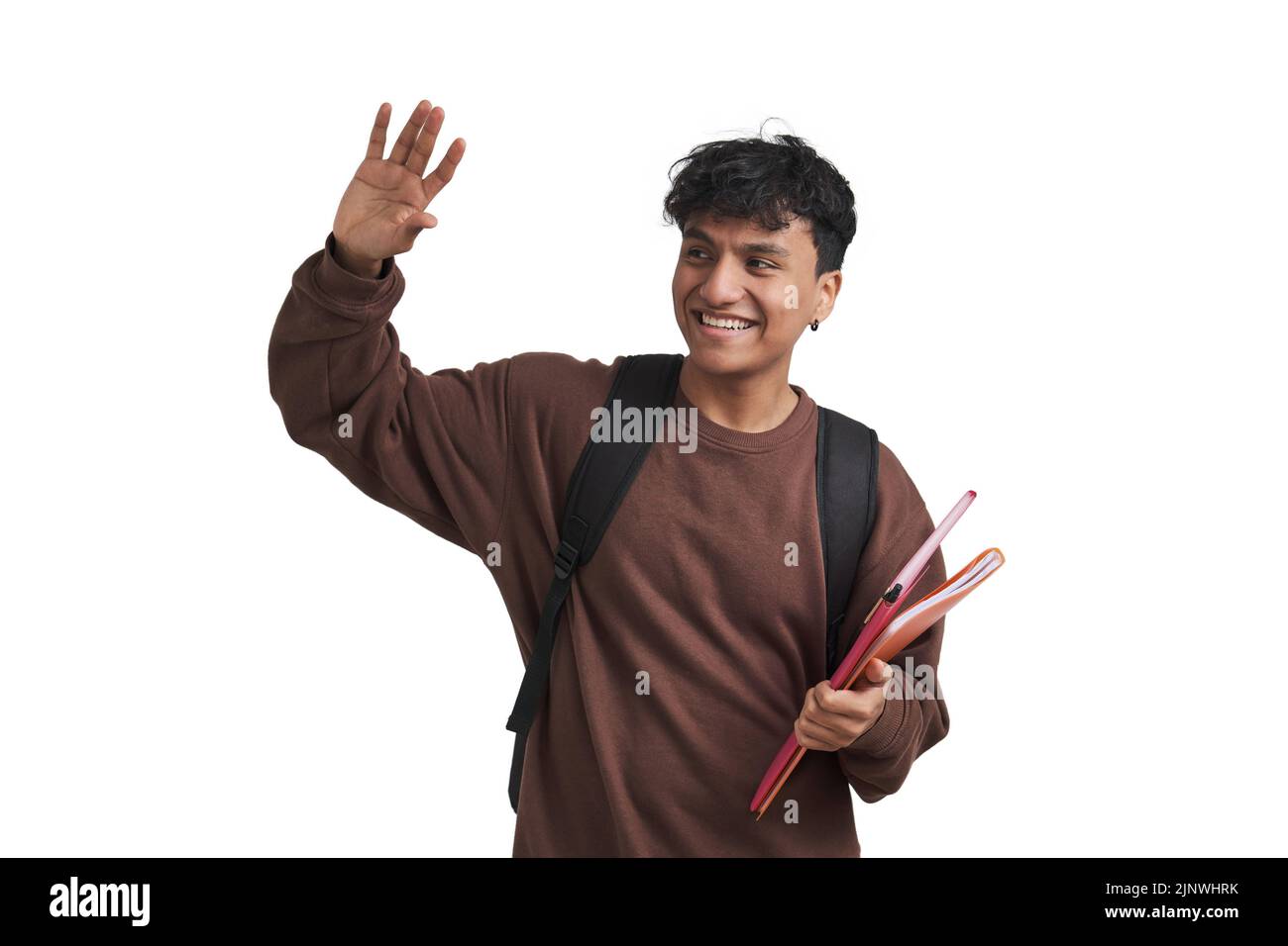 Young peruvian student waves and smiling, holds folders and backpack, isolated. Stock Photo