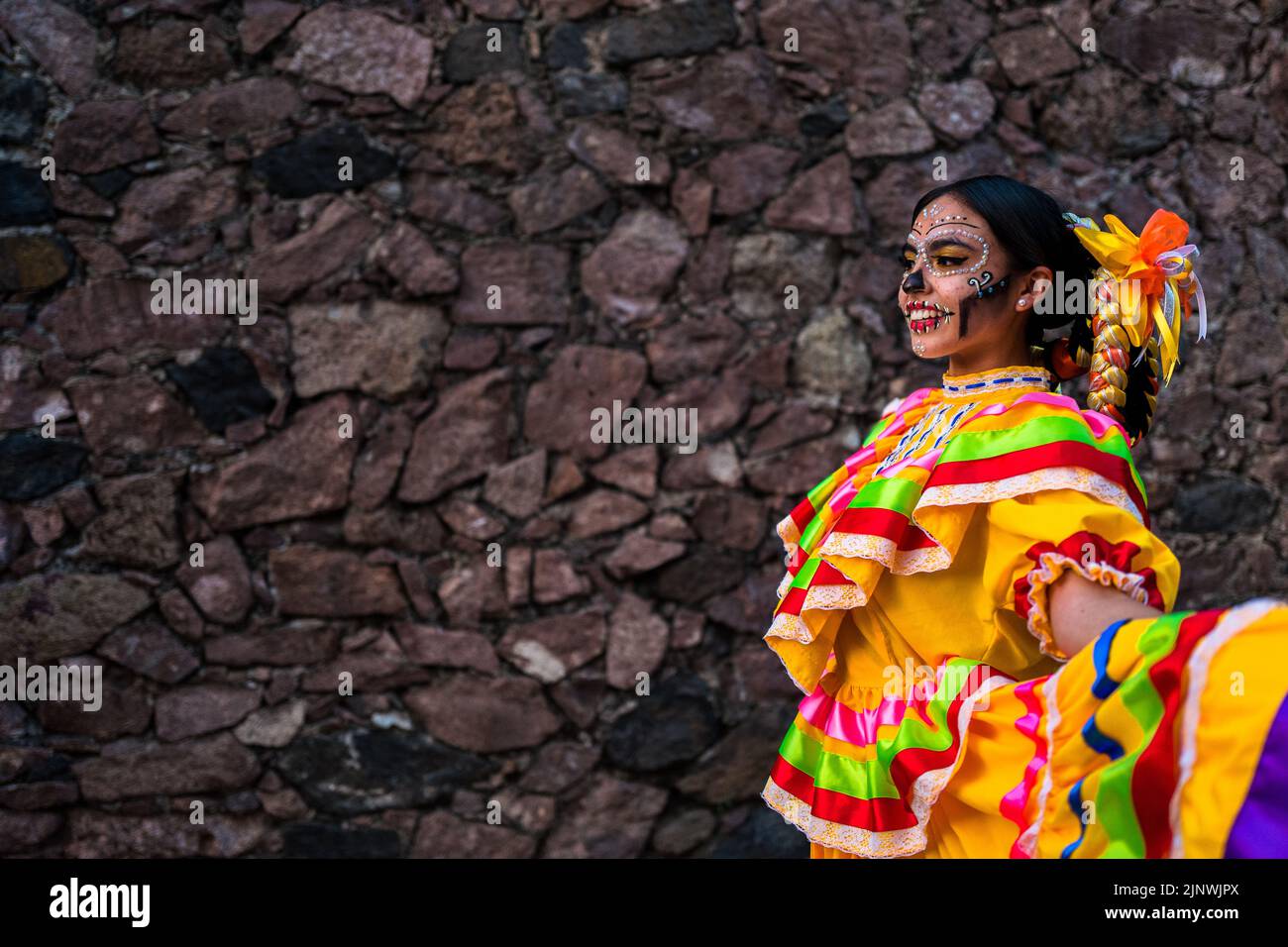 A Mexican girl, dressed as La Catrina, a Mexican pop culture icon, dances during the Day of the Dead celebrations in Taxco, Mexico. Stock Photo