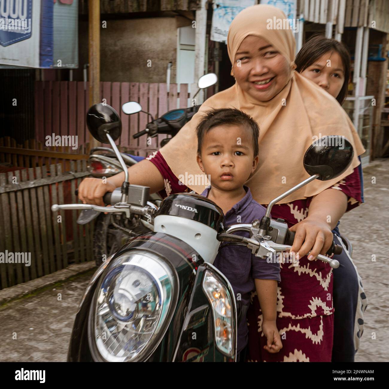 Single File Motorcycel Riding Central Kalamantan, Indonesia, May 20, 2022 - Entire family rides on a ...
