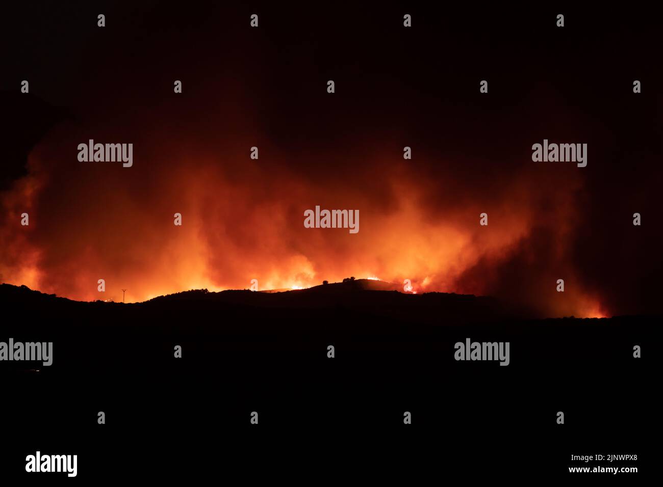 View of forest fire flames in the Moncayo, devouring hills and trees with virulence, thanks to hurricane force winds and drought Stock Photo