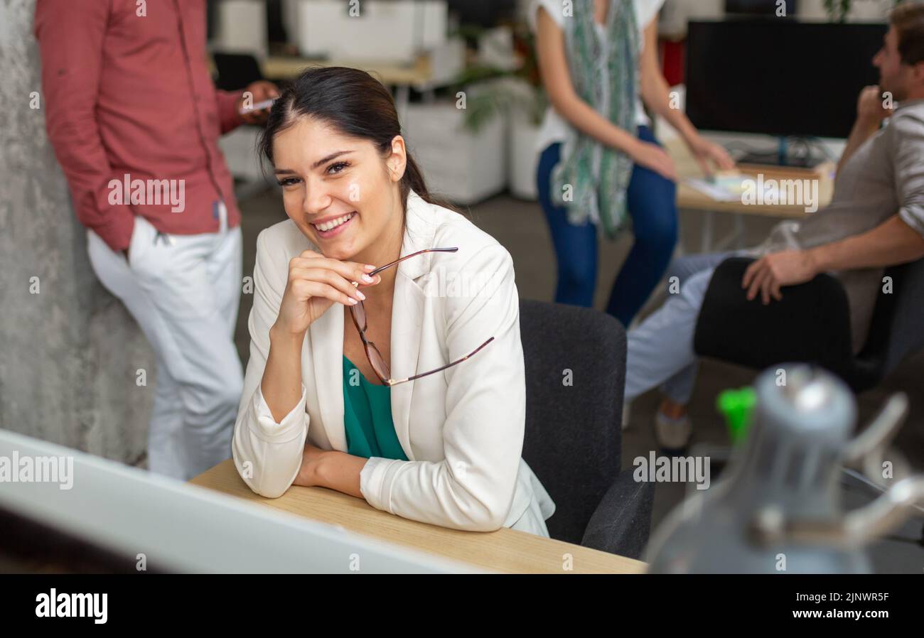 Group of software engineers working developing applications together in corporate office Stock Photo