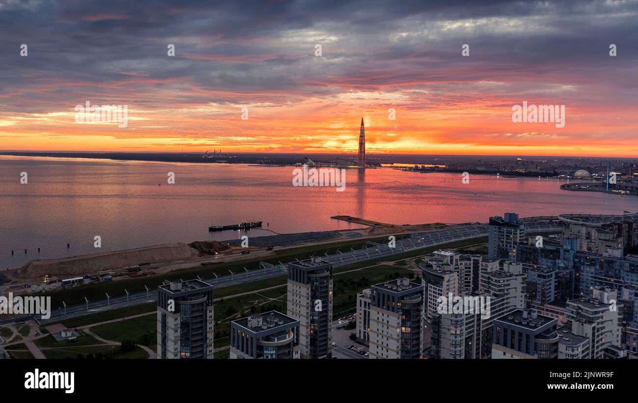 The Gulf of Finland and the sun setting behind the Lakhta Center tower. Red sunset over Saint Petersburg, Russia panoramic aerial view. Stock Photo