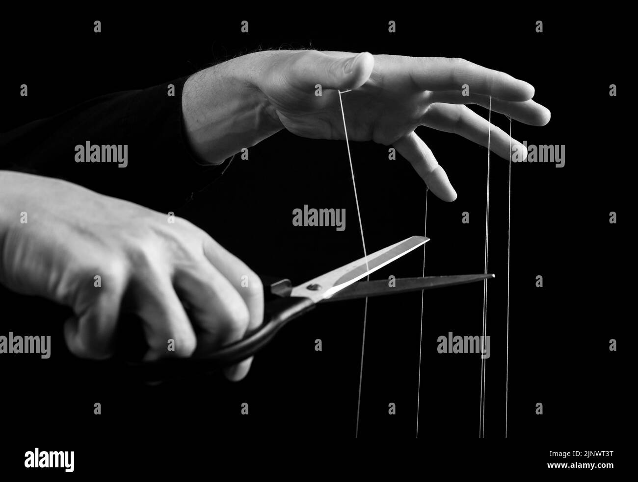 Cutting string of manipulator master hand. Get freedom from influence, dictatorship. Stock Photo