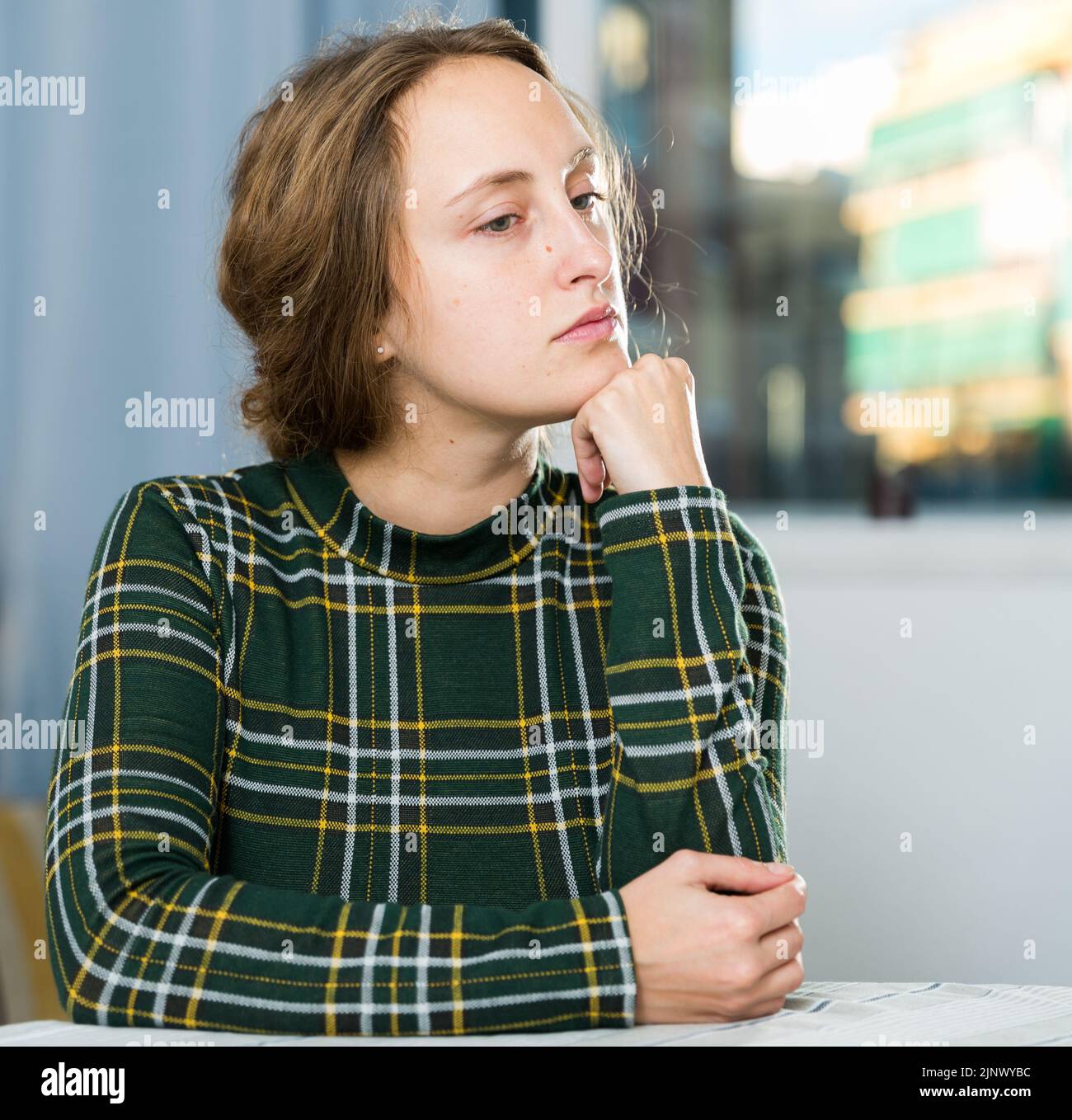 Portrait of sorrowful woman sitting at home Stock Photo