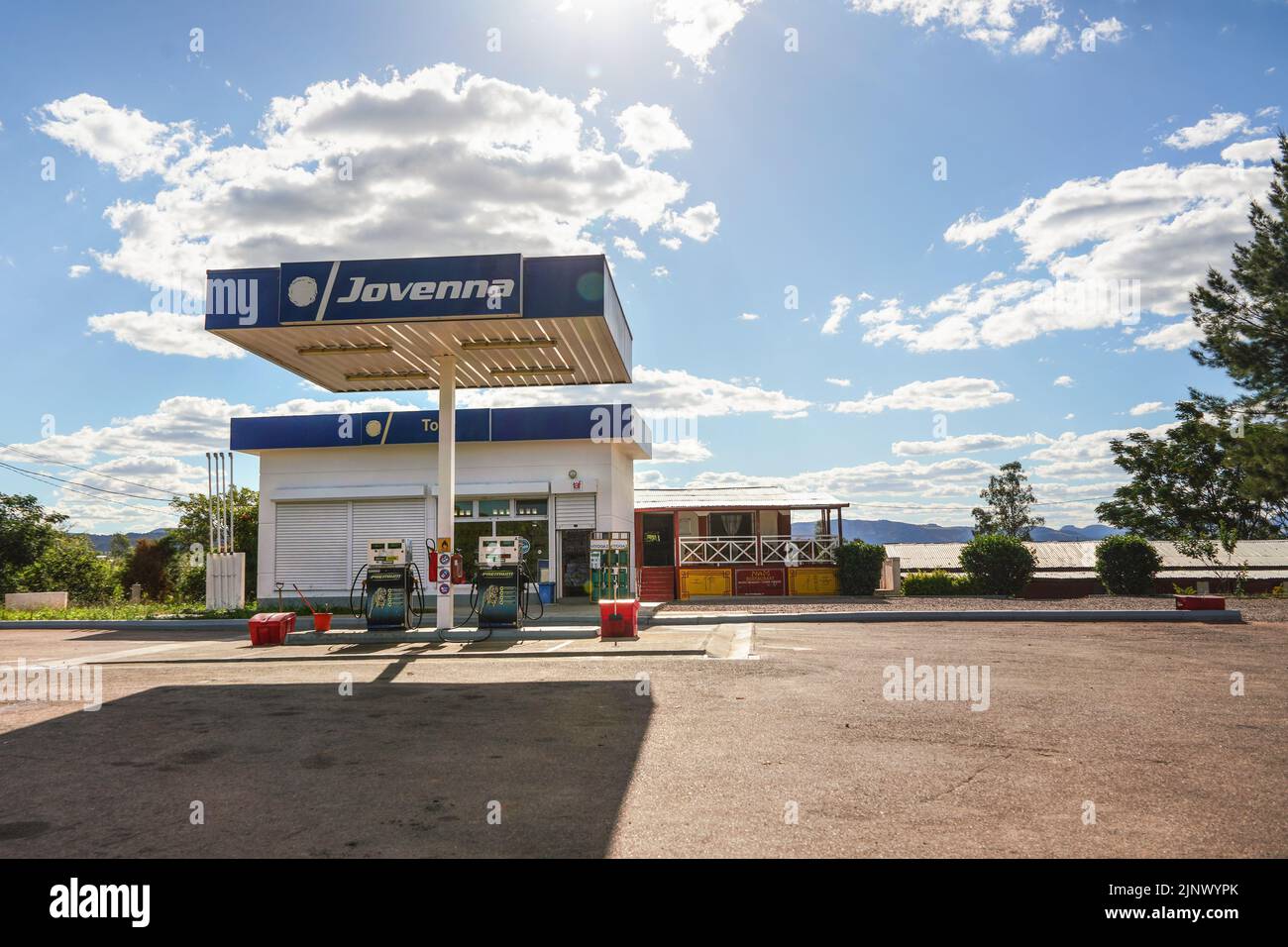 Ranohira, Madagascar - May 05, 2019: Typical gas station (blue Jovenna brand) at Madagascar on sunny day. Empty concrete parking lot in front of fuel Stock Photo
