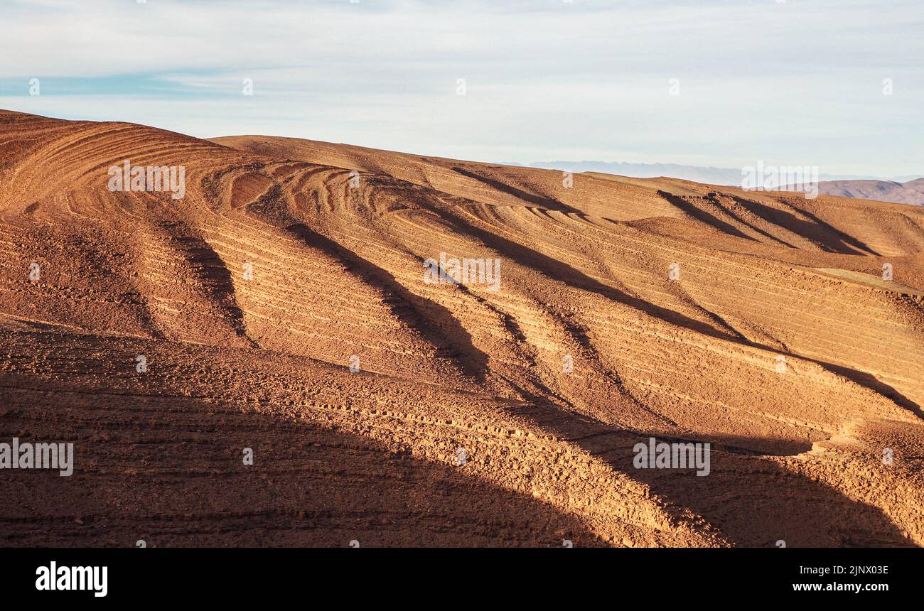 Panorama of hills with regular brown soil pattern in Tizi'n-Tinififft pass Ouaourmas Morocco, blue sky above Stock Photo