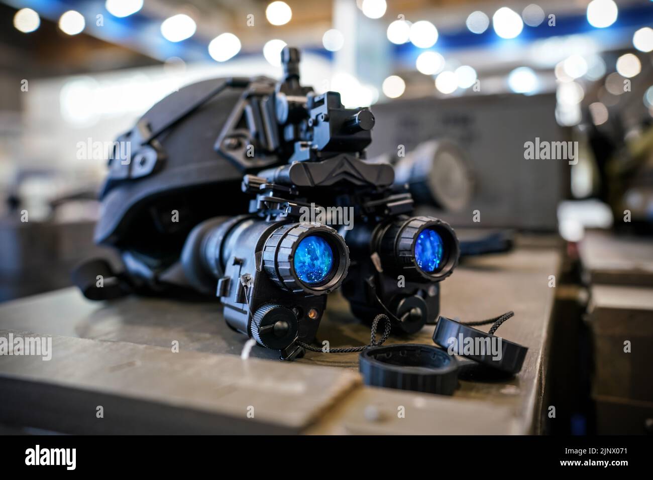 Night vision goggles on military helmet, closeup detail to blue reflective lenses Stock Photo