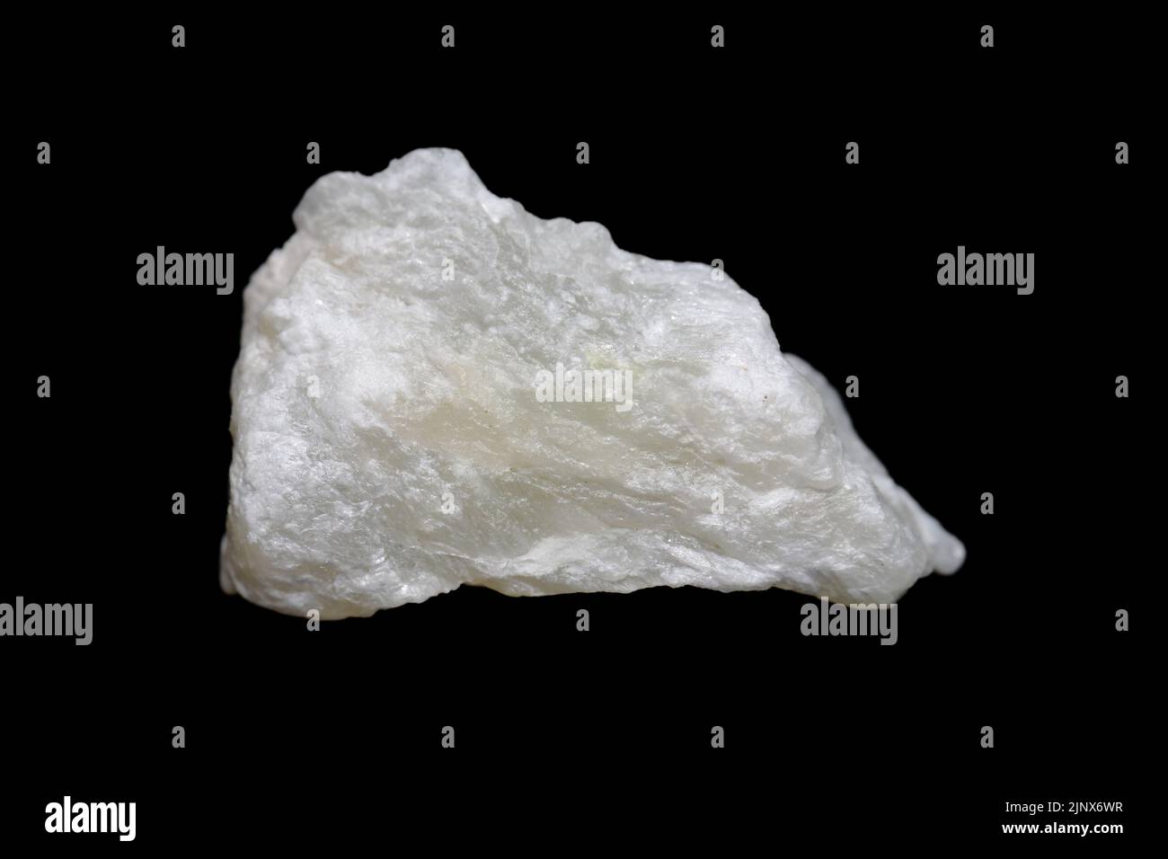 Raw Talc (talcum) stone on dark background, talc is a clay mineral used in many industries ex. powder, cosmetic, paint Stock Photo