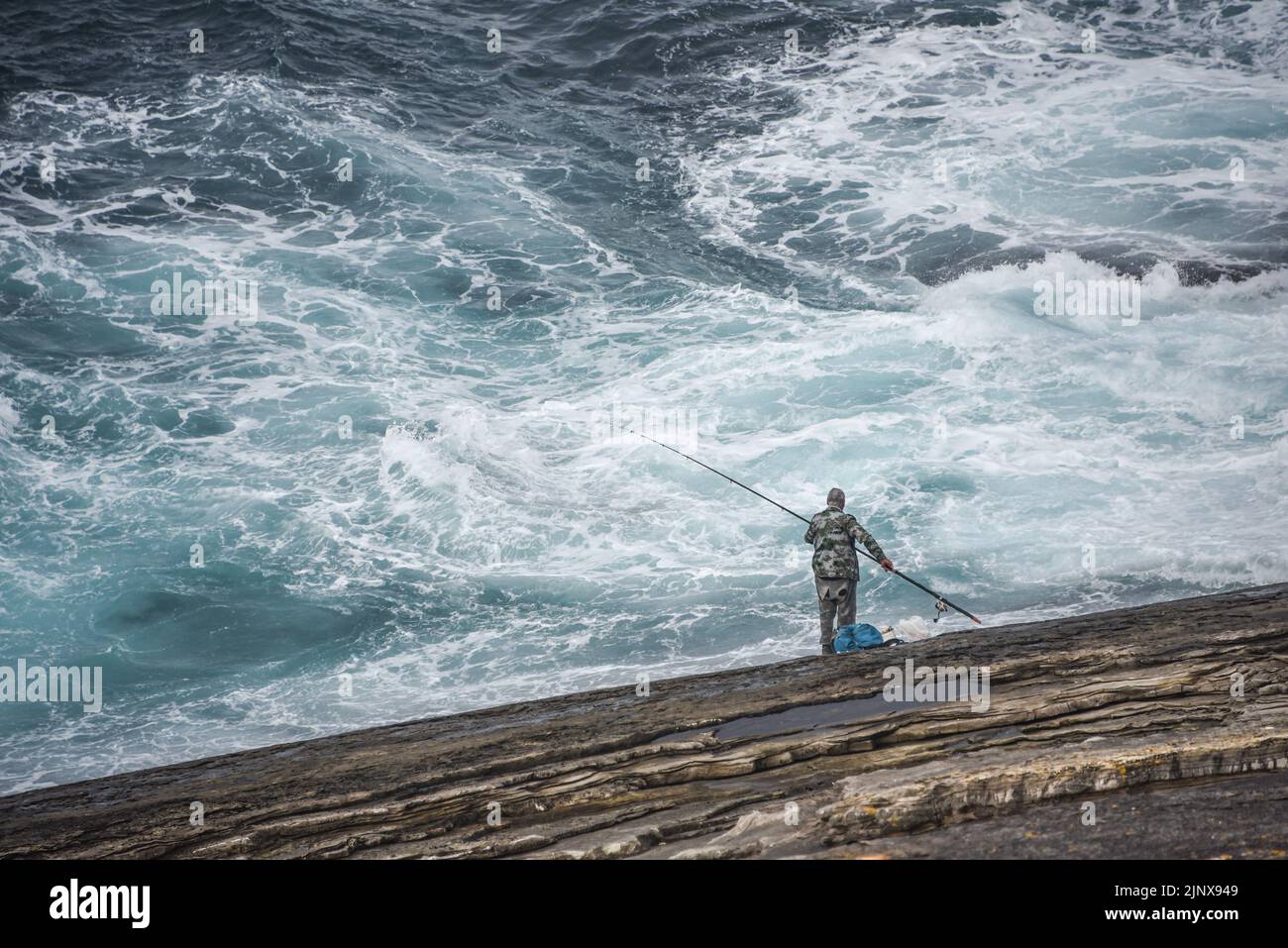 A man fishing off the Cantabrian coast in the Basque Country. San Sebastian, Spain Stock Photo