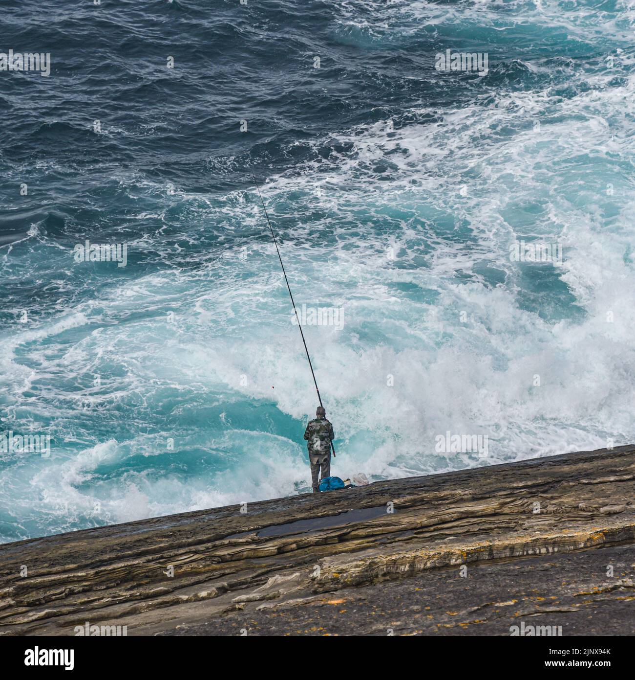 A man fishing off the Cantabrian coast in the Basque Country. San Sebastian, Spain Stock Photo