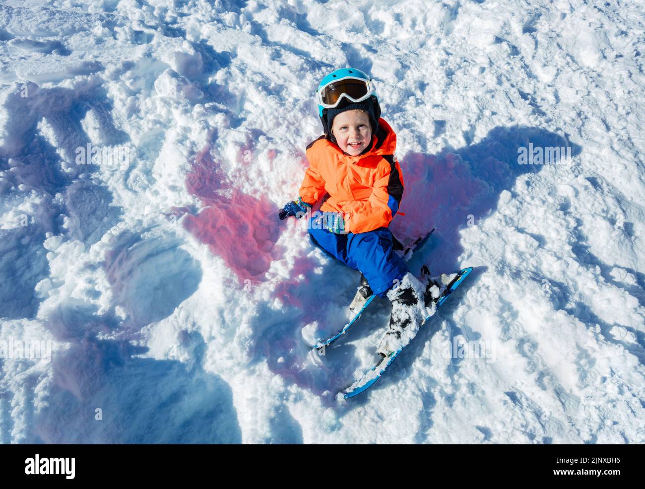 View from above of smiling little boy with ski and winter outfit Stock Photo