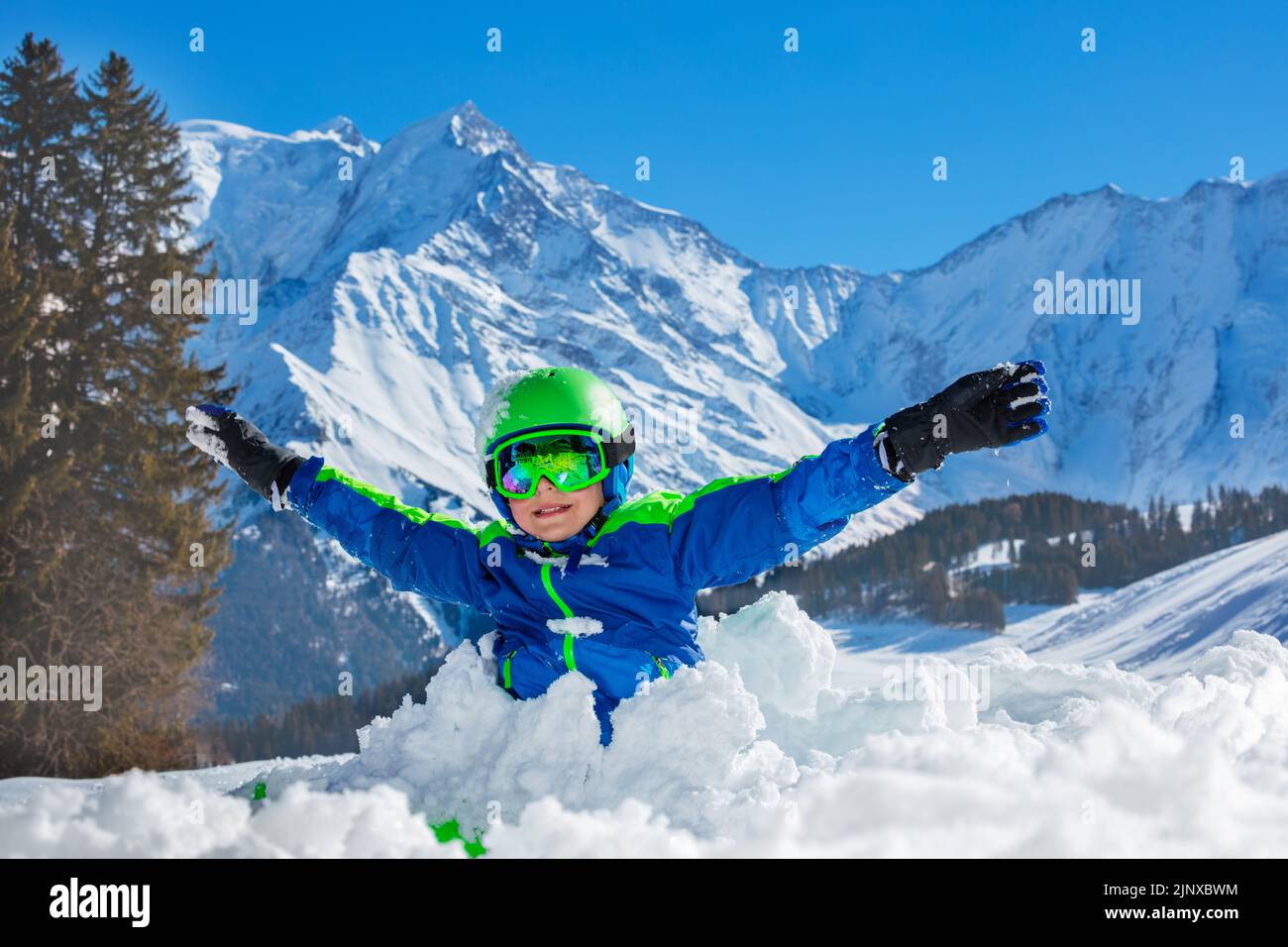 Boy play standing with lifted up hands in snowdrift Stock Photo