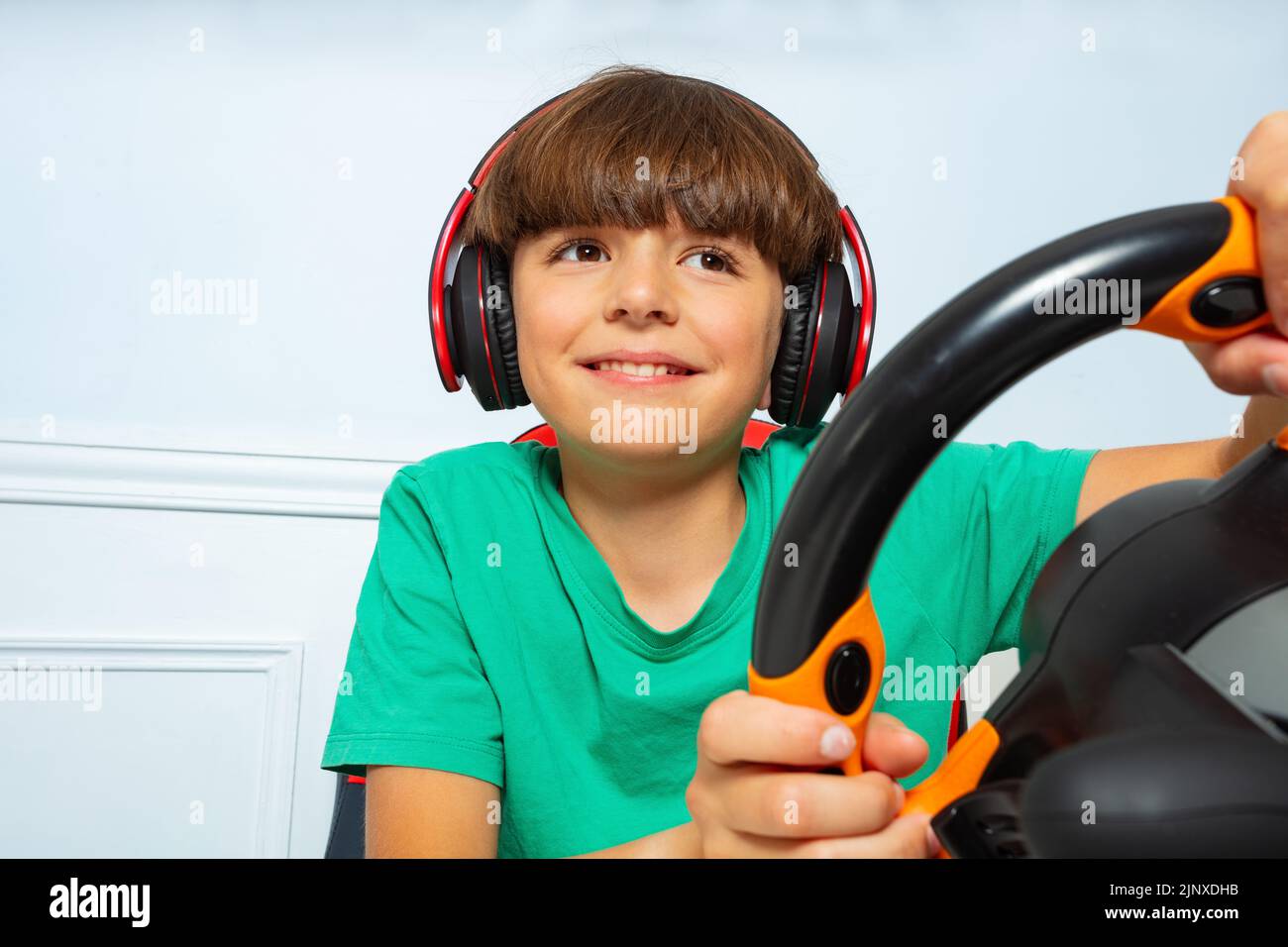 Close image with steering wheel of gamer young boy playing game Stock