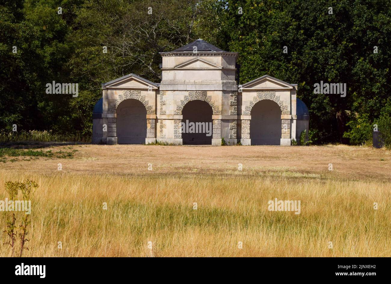 London, UK. 14th August 2022. Dry grass surrounds Queen Caroline's Temple in Kensington Gardens as a drought is officially declared in parts of England. Credit: Vuk Valcic/Alamy Live News Stock Photo