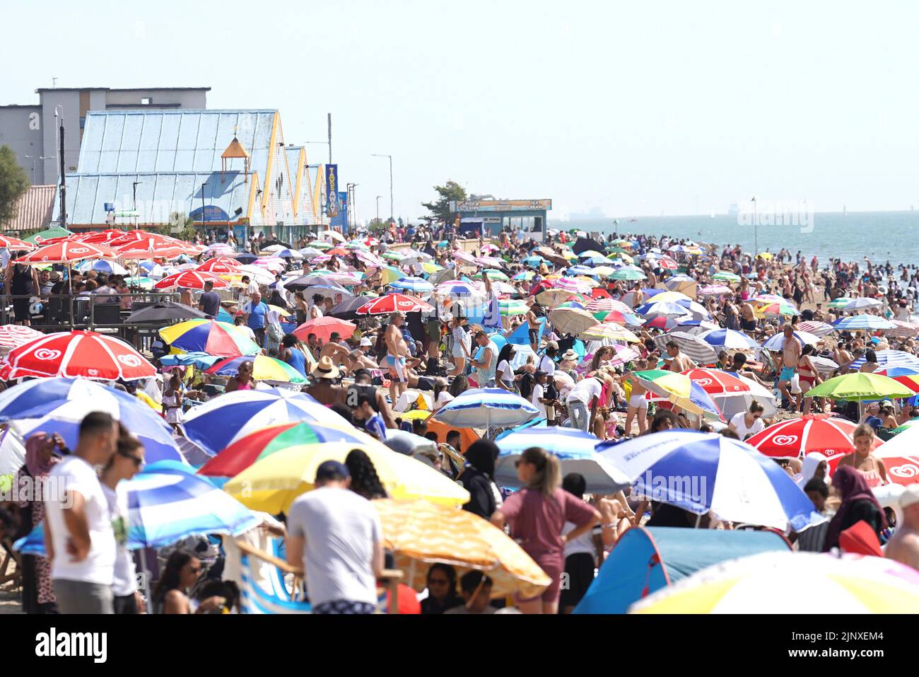 People gather in the hot weather at Southend-on-Sea beach. A drought has been declared for parts of England following the driest summer for 50 years. Picture date: Sunday August 14, 2022. Stock Photo