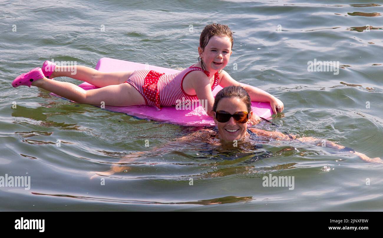 Mother with children paddle boarding in the sea on holiday Stock Photo