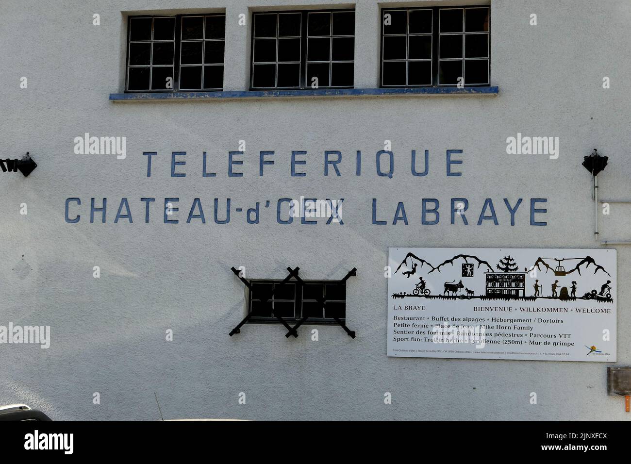  The image shows a building with a sign that says 'Chateau d'Oex La Braye' in French and 'Telepherique' above it. It also has a sign that says 'La Braye' with a skier on it.