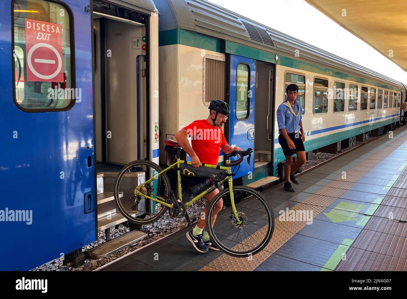 Boy scouts get off the train with their bicycles. Milan, Italy - August 2022 Stock Photo