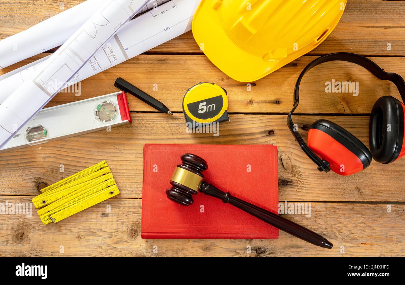 Construction and Labor law flat lay. Judge gavel and engineering tools on wooden table, top view. Stock Photo