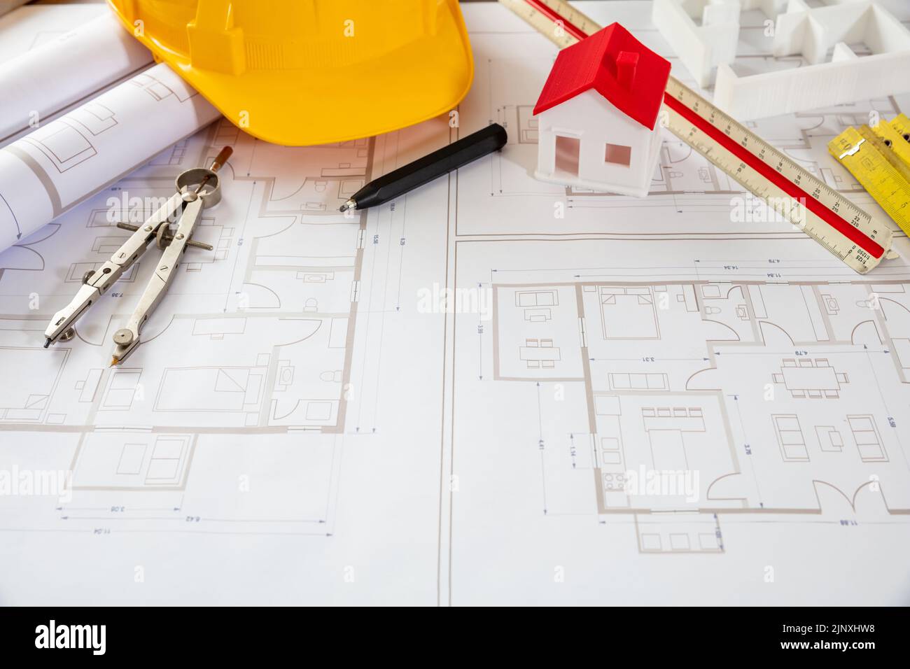 Architect engineer office. Construction safety helmet and engineering tools on building blueprint plans, copy space Stock Photo