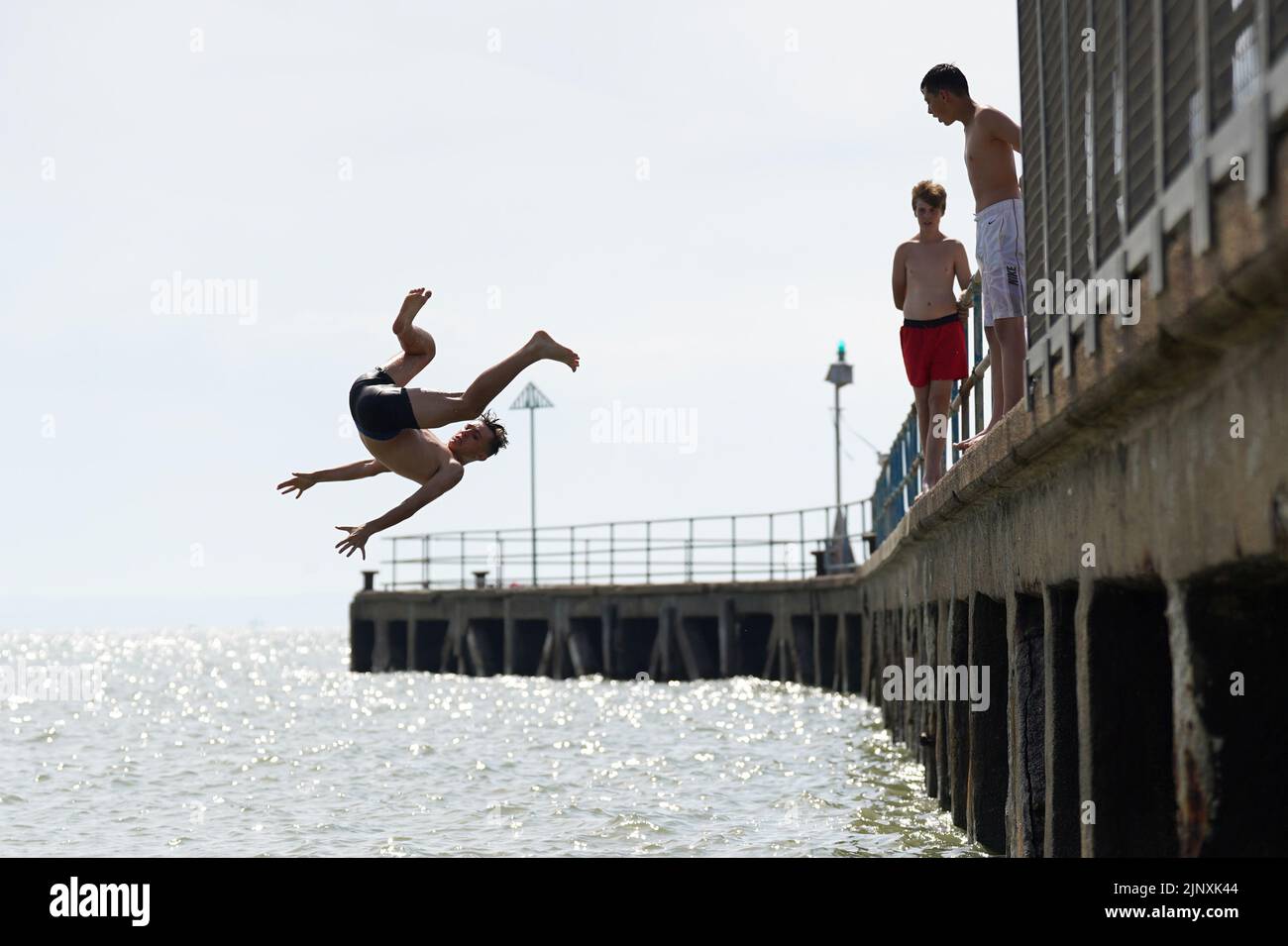 People diving off the pier at Southend-on-Sea. A drought has been declared for parts of England following the driest summer for 50 years. Picture date: Sunday August 14, 2022. Stock Photo