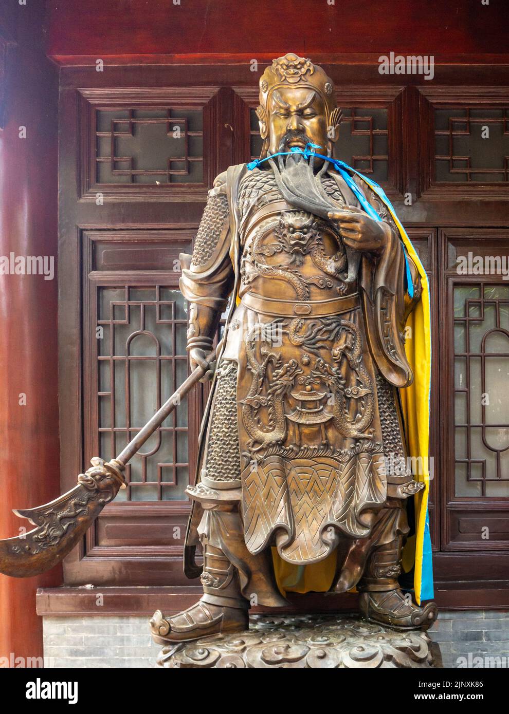 Old metallic religious sculpture or statue. The symbol of the Chinese culture is set outside a temple building. Stock Photo