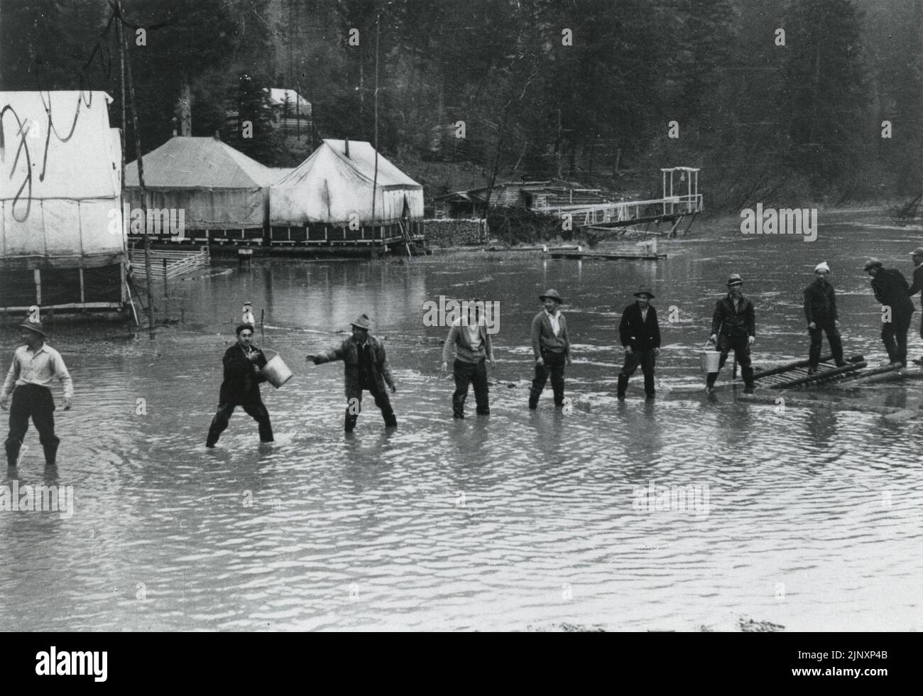 Title: View of workers battling flood waters at Decoigne Camp  Reminder: Reminder: No known copyright restrictions. Please credit UBC Library as the image source. For more information see http://digitalcollections.library.ubc.ca/cdm/about.   Date: 1942-05  Access Identifier: JCPC  05 011  Source: Original Format: University of British Columbia Library. Rare Books are Special Collections. Japanese Canadian Research Collection. JCPC  05 011  Permanent URL: http://digitalcollections.library.ubc.ca/cdm/ref/collection/jphotos/id/258 Stock Photo