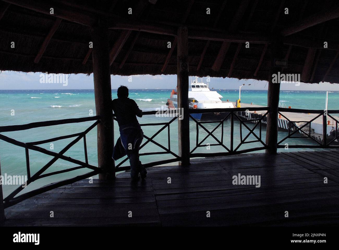 Silhouette of a man at the maritime station watching Ferries moored ready to depart in Playa del Carmen, Mexico Stock Photo