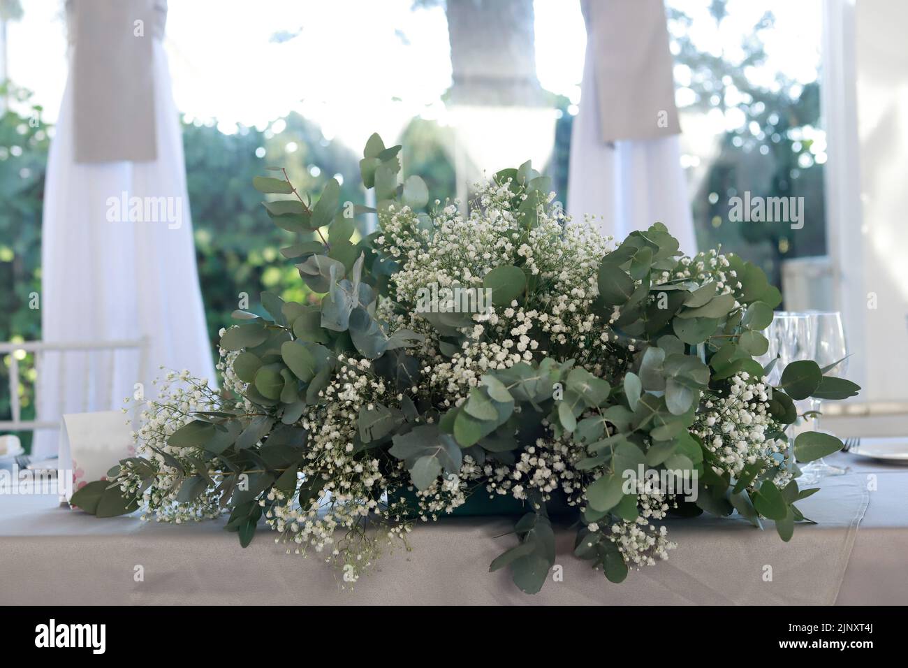 bride and groom's table with eucalyptus and breeze floral arrangement Stock Photo