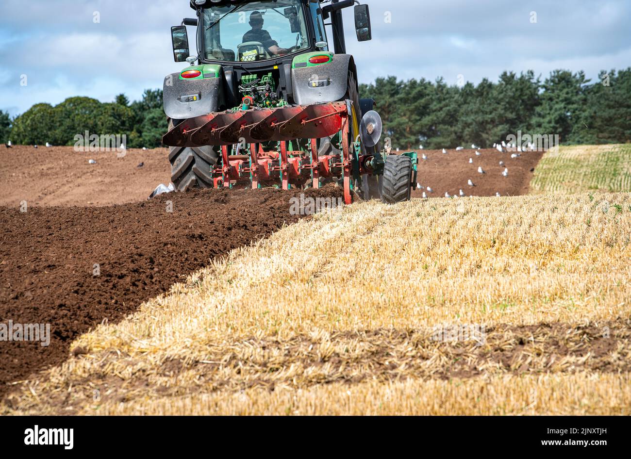 A tractor ploughing  in the Scottish Borders, Scotland, United Kingdom Stock Photo