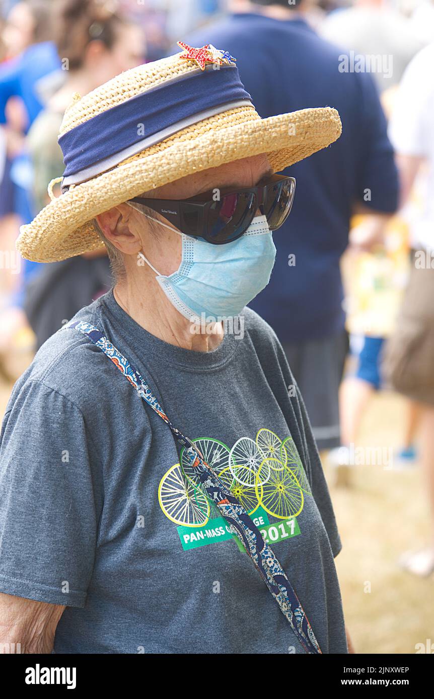 A masked senior citizen at a church flea market in Dennis, Massachusetts on Cape Cod Stock Photo