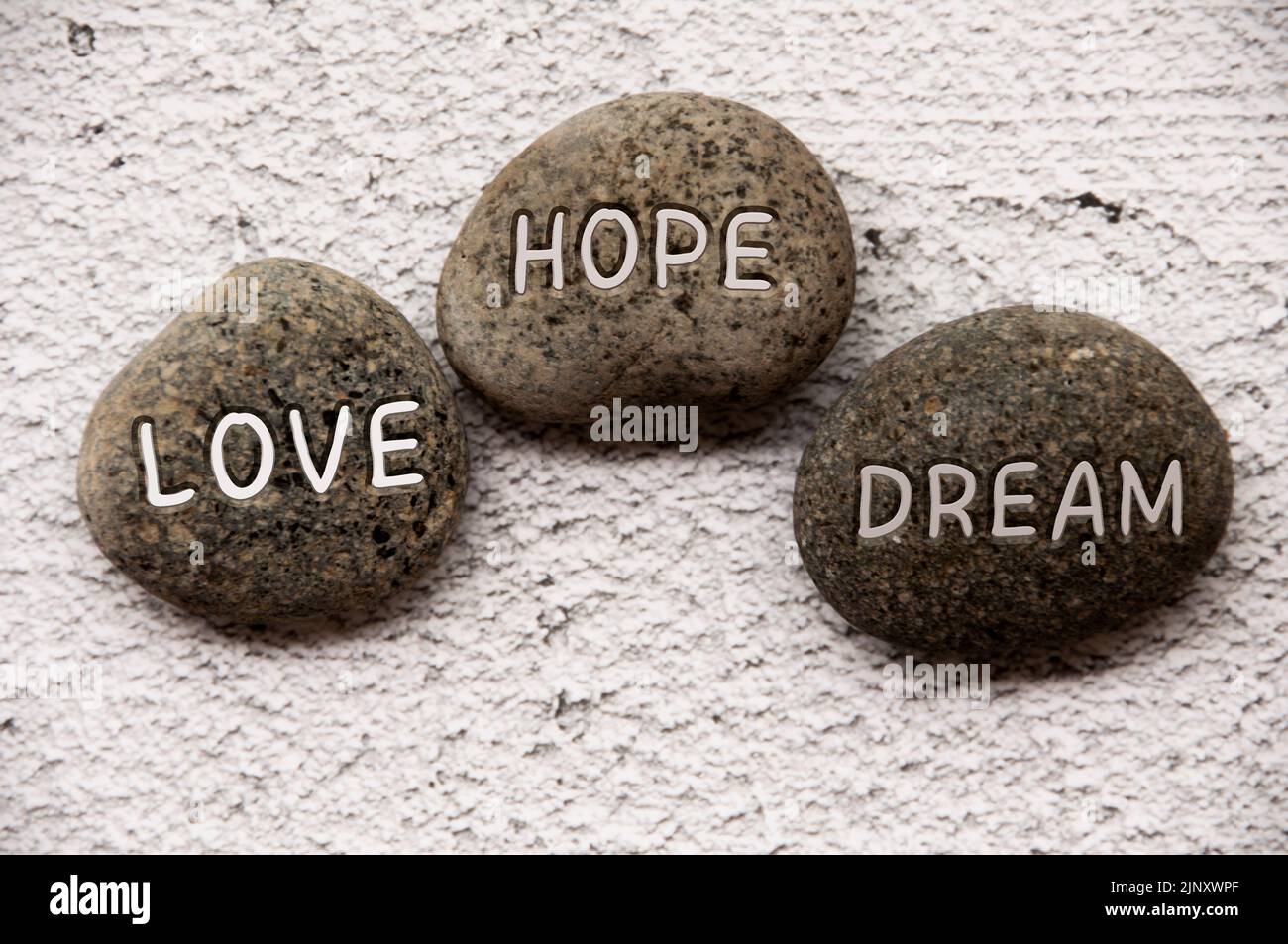 Love, hope and dream text engraved on stones. Life concept. Stock Photo