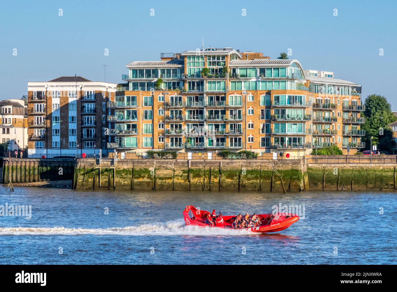 A RIB of Thames Rockets travelling past the Rotherhithe Peninsula on the River Thames, London. Stock Photo