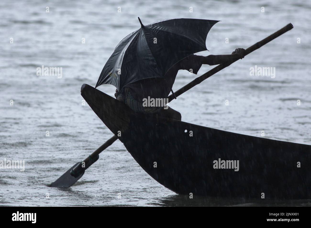 Dhaka, Bangladesh. 14th Aug, 2022. A Bangladeshi boatman rows his boat across the Buriganga river on a rainy day. (Credit Image: © Md Manik/SOPA Images via ZUMA Press Wire) Stock Photo