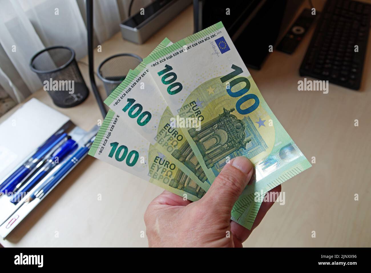 Symbolic photo: Relief package in Germany for rising energy costs: Three hundred euro bills in hand Stock Photo