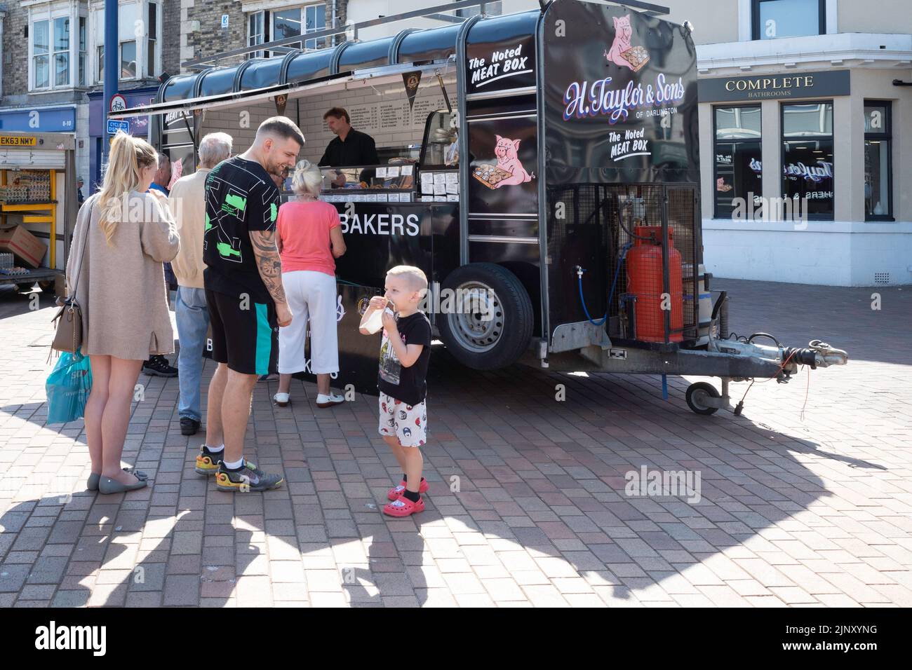 A queue waiting to buy from H Taylor and Sons meat and pie stall in the weekly market in Redcar Stock Photo