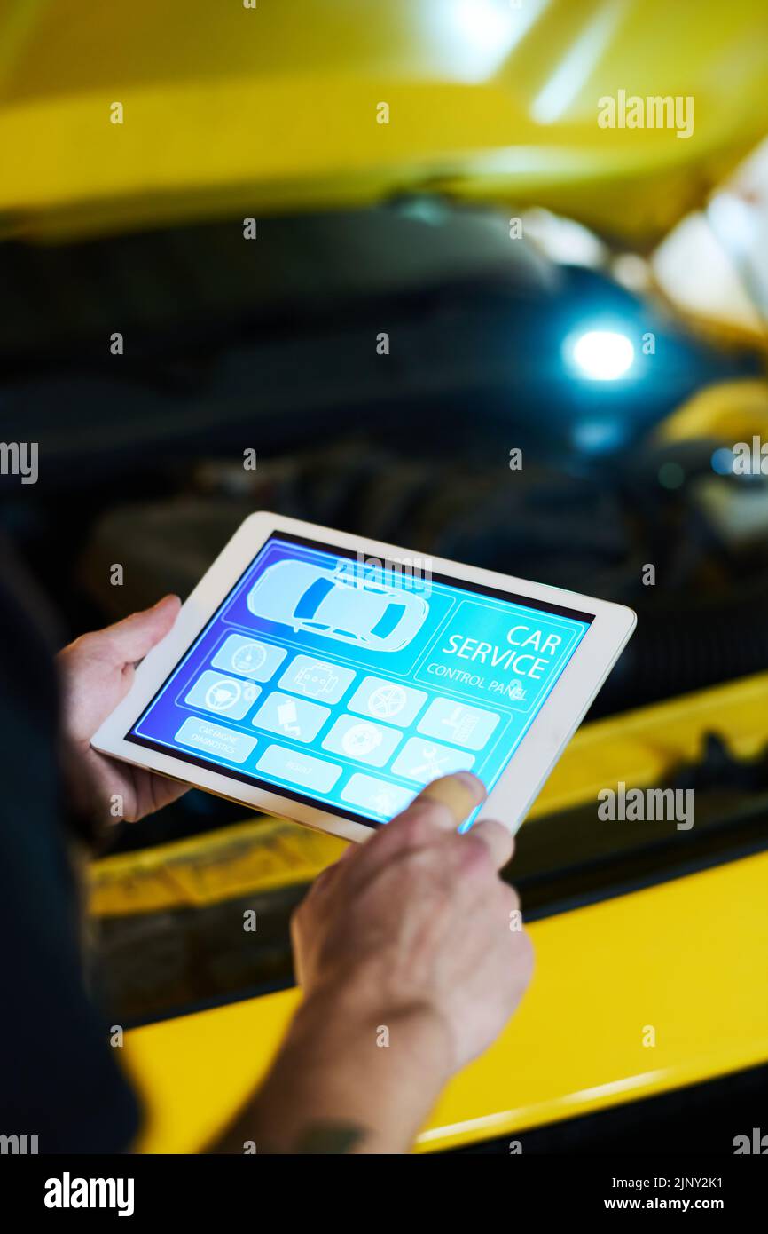 Hand of young engineer of maintenance service shop pointing at icon on tablet screen while visiting homepage of website Stock Photo