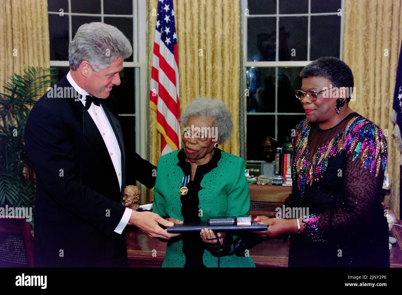 U.S. President Bill Clinton, presents 87-years old Oseola McCarty, center, of Hattiesburg, Mississippi with the Presidential Citizens Medal as her cousin Mary McCarthy, right, assists during a ceremony in the Oval Office of the White house, September 23, 1995 in Washington, D.C. McCarthy spent her life as a washerwoman but saved $150,000 to create a scholarship for poor students to attend the University of Southern Mississippi. Stock Photo