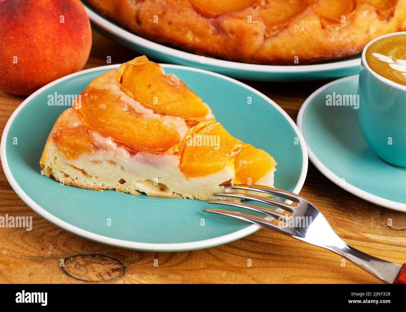 Piece of homemade pie with peaches and cup of coffee on wooden table. Shallow focus. Stock Photo