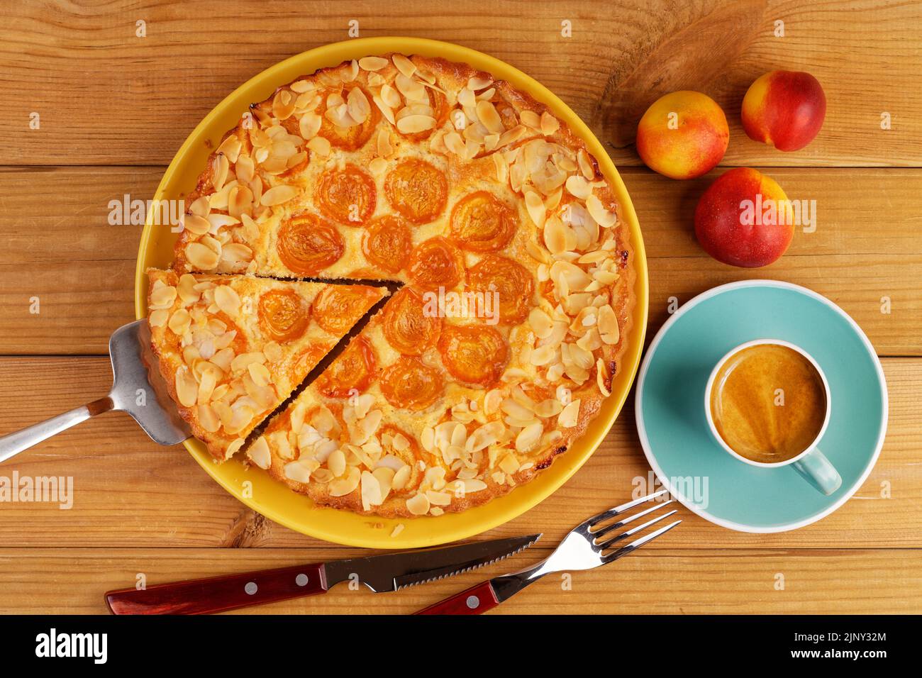 Closeup homemade pie with apricots and cup of coffee on wooden table. Top view. Stock Photo