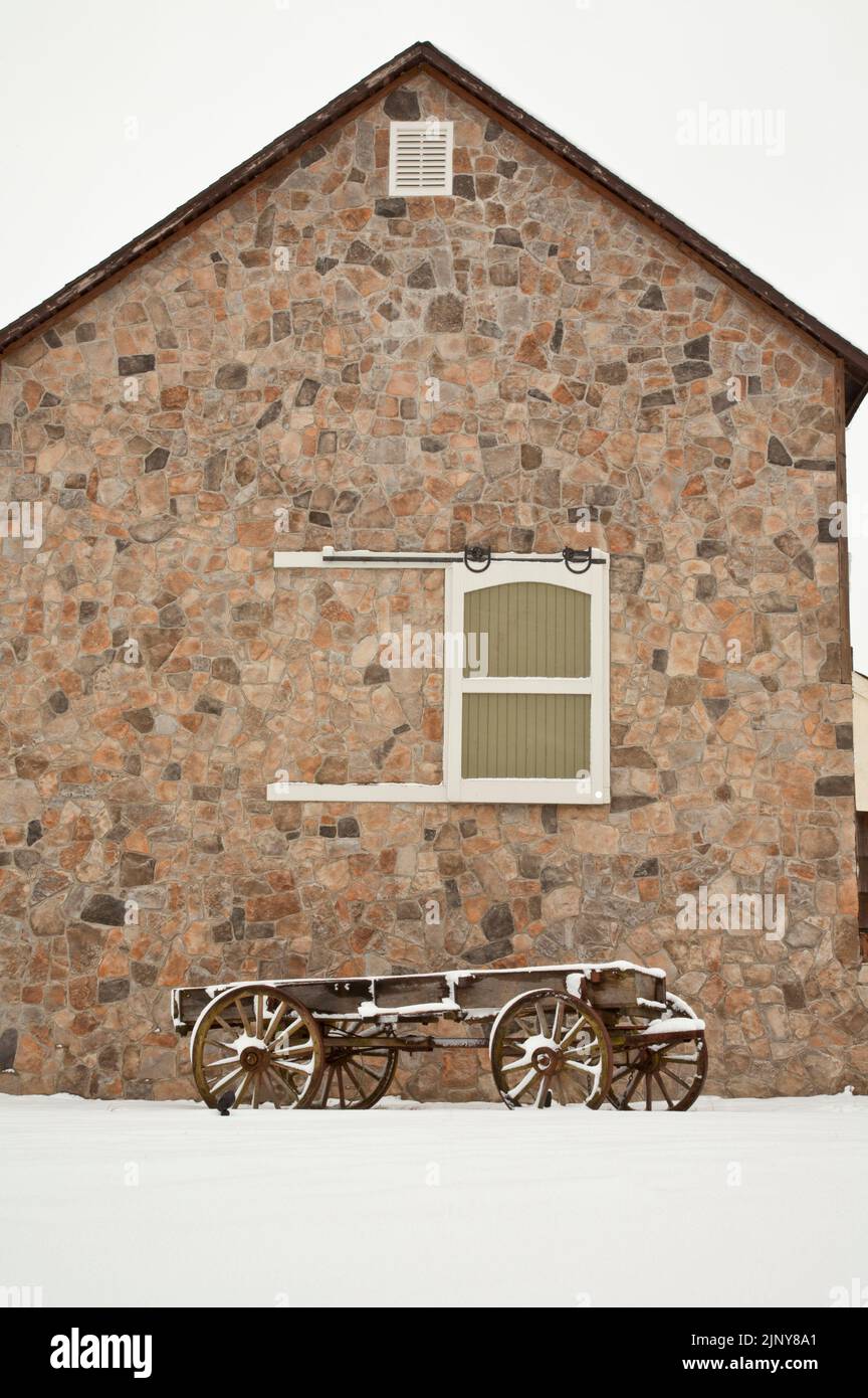 Brown stone barn with a vintage wagon in winter snow snowing farm scene, Millstone, New Jersey