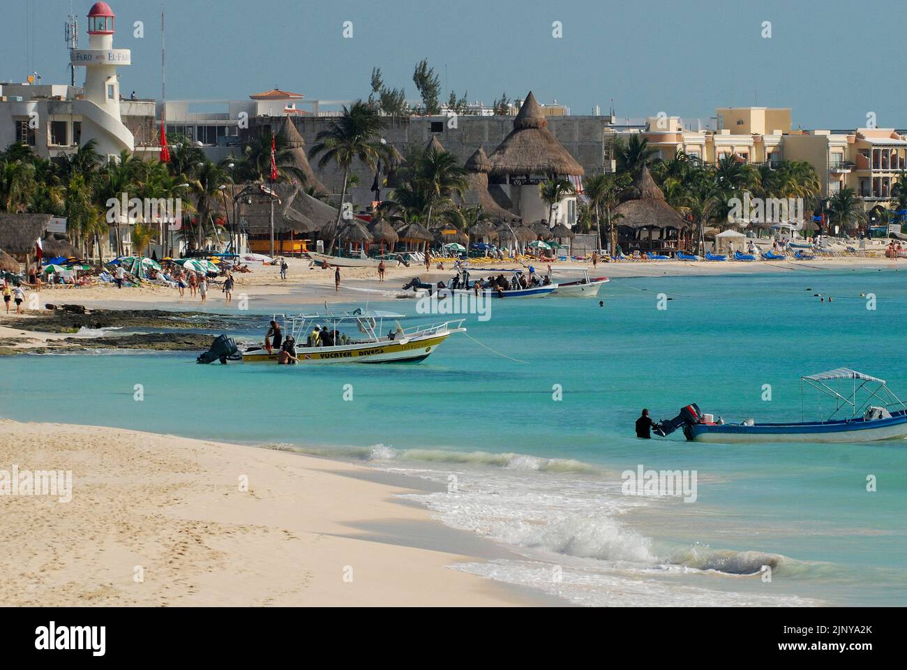 View of the waterfront in Playa del Carmen, Mexico, with the lighthouse and fishing boats near the beach Stock Photo