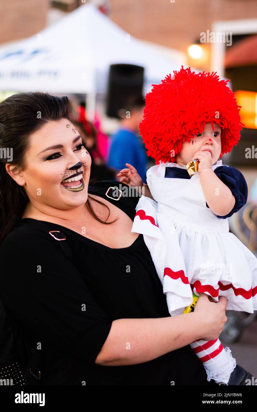 Mom holding baby daughter wearing Raggedy Ann doll Halloween costume at ...