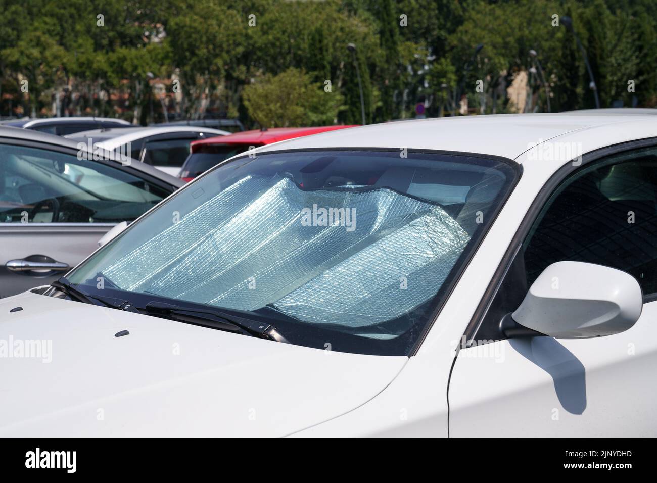 Protective reflective surface under windshield of car on hot day