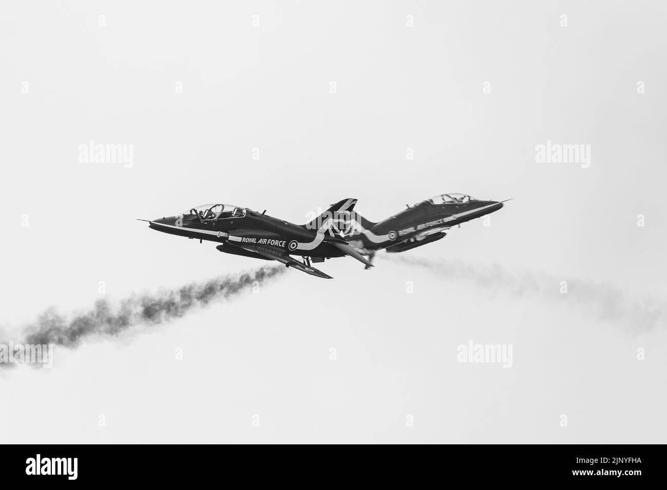 Black and white image of the Red Arrows synchro pair crossing over at Blackpool, Lancashire in August 2022. Stock Photo