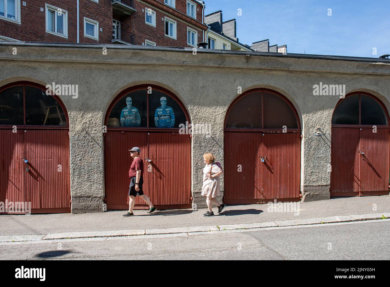Elderly couple passing Franzeninkatu garages in Helsinki, Finland Stock Photo