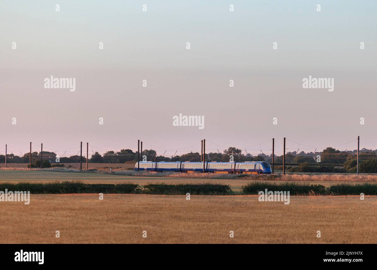Open access operator Firstgroup Lumo class 803 electric train on the 4 track east coast mainline railway in Yorkshire passing the arable countryside Stock Photo