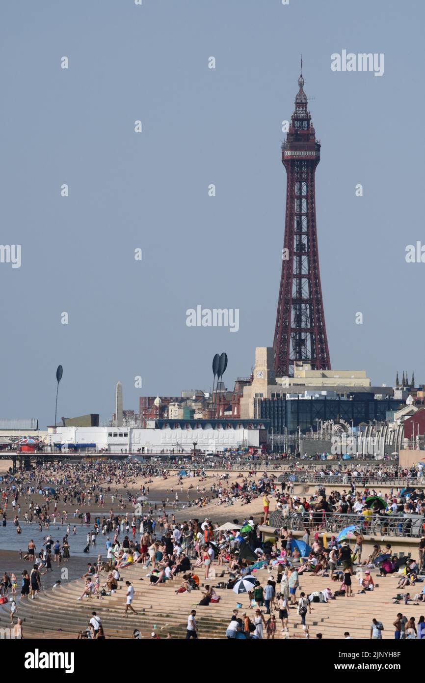 Blackpool, Lancashire, UK.  14 August '22.   UK weather:  People out on the seafront this afternoon, with the Blackpool Airshow on it's 2nd day.  Credit: Andrew Bartlett/Alamy Live News Stock Photo