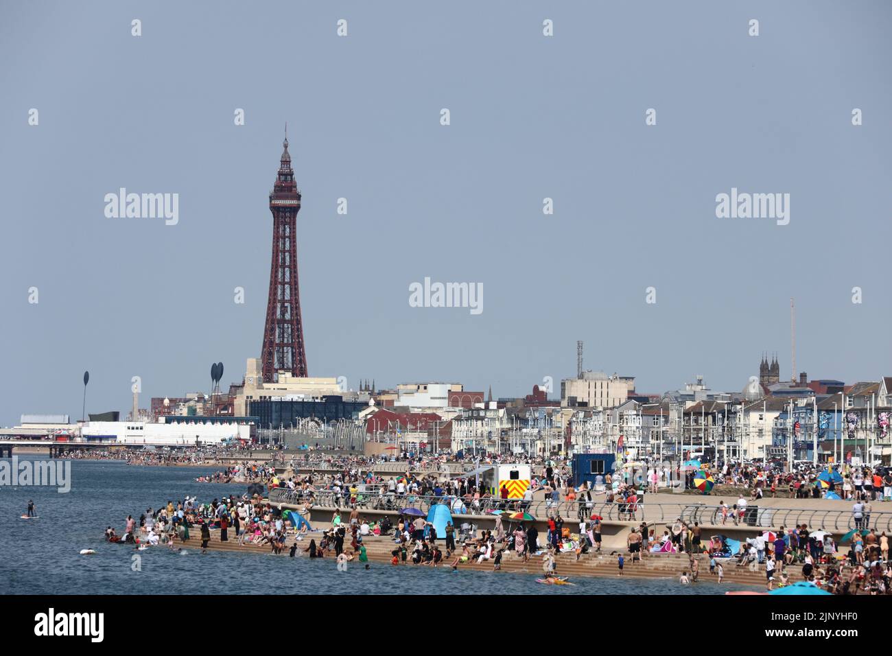 Blackpool, Lancashire, UK.  14 August '22.   UK weather:  People out on the seafront this afternoon, with the Blackpool Airshow on it's 2nd day.  Credit: Andrew Bartlett/Alamy Live News Stock Photo